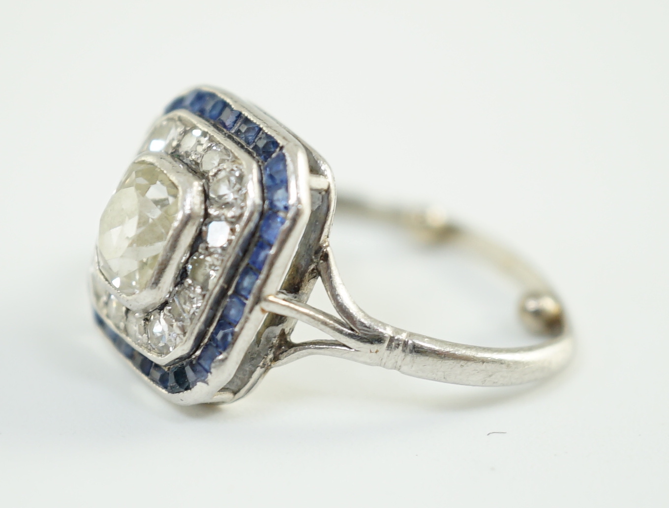 An Art Deco platinum, diamond and sapphire set rectangular cluster ring